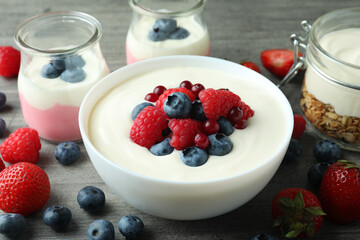 Concept of tasty breakfast with yogurt on gray textured table