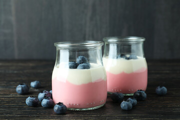 Concept of tasty breakfast with yogurt on wooden table