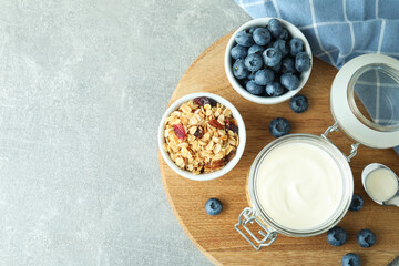 Obraz na płótnie Canvas Concept of tasty breakfast with yogurt on gray textured table