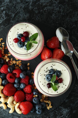 Concept of tasty breakfast with yogurt on black smokey table
