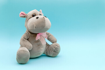 Stuffed animal hippo on blue background. Child soft toy, comforter for sleep. 