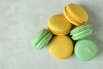 Concept of tasty dessert with macaroons on white textured background