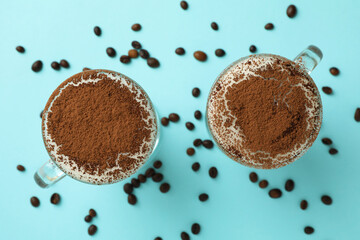 Glasses of irish coffee and coffee seeds on blue background