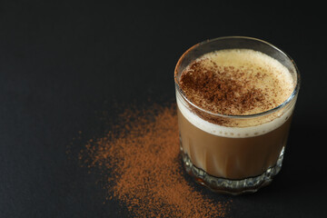 Glass of irish coffee on black background