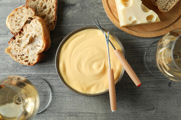 Concept of delicious food with fondue on gray textured table