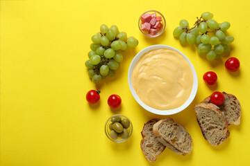 Concept of delicious food with fondue on yellow background