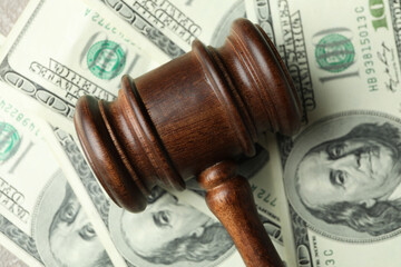 Judge gavel on dollar bills background, close up