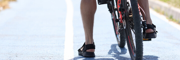Naklejka premium Man begins to move on bicycle while standing on cycle path