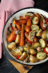 Oven baked potatoes, carrots, garlic, onions with chili, thyme and rosemary