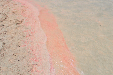 A strip of pink sand on the seashore in Greece.