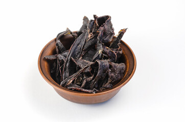 Dried dog treats in a brown clay bowl on a white background. Thi