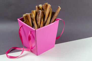 Pretty pink gift box with pet treats. Open box full of bully sti