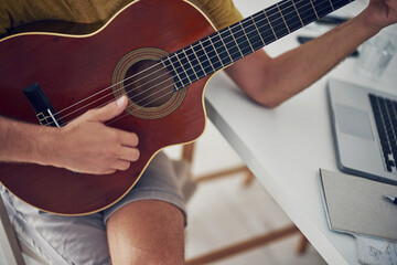 Man playing acoustic guitar at home.