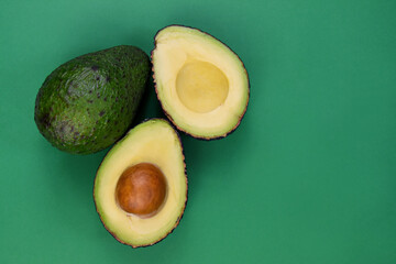Whole and half avocado isolated on a green background stock images. Raw fresh avocado isolated on a...