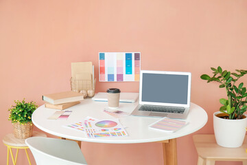 Stylish workplace of graphic designer with laptop in office