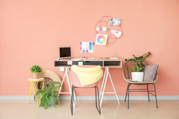 Stylish workplace of graphic designer with laptop in office