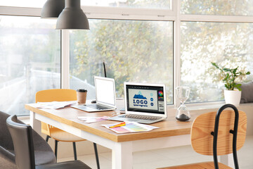 Stylish workplace of graphic designer with laptops in office
