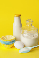 Ingredients for preparing muffins on color background