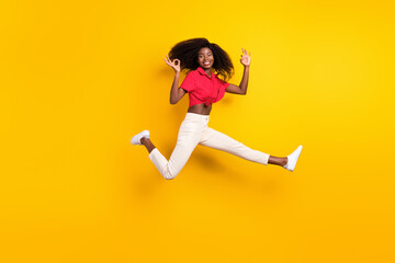 Fototapeta na wymiar Full size photo of young happy cheerful lovely afro girl jumping showing okay sign isolated on yellow color background