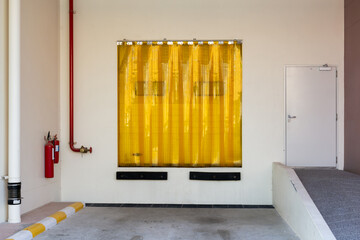 Industry door entrance with Transparent yellow plastic strip curtain.