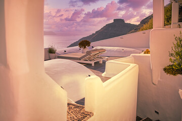 Sun beds romance on the rooftop at sunset in Santorini Island, Greece, Oia. Beautiful caldera view...