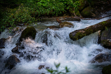 a strong flow in a mountain creek with melting water from the alps in summer