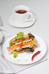 Banh mi sandwiches with various stuffing and cup of tea. Traditional vietnamese breakfast. Trendy still life in light colors.