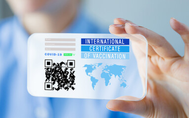 technology and health care concept - close up of woman's hand showing transparent smartphone with virtual immunity passport or international certificate of vaccination on screen