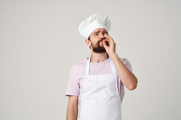 man in chef's clothes cooking food kitchen profession light background