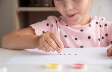 The concept of creative drawing. The child draws cotton buds.