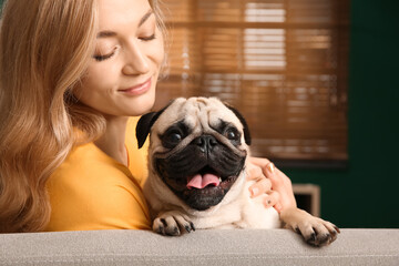 Woman with cute pug dog at home. Animal adoption