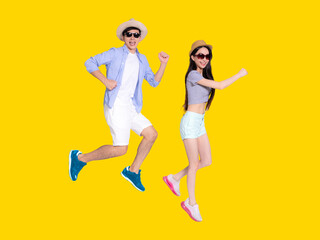 Fototapeta na wymiar Happy Young couple in sunglasses and jumping .Isolated on yellow background.