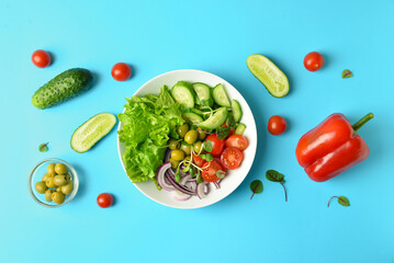 Plate of delicious fresh salad and different vegetables on color background