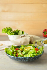 Plate of tasty fresh vegetable salad on wooden table