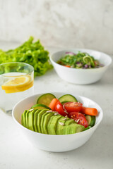 Bowl with delicious vegetable salad on light background