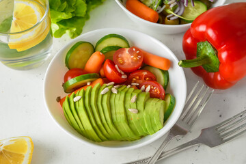 Bowl of salad with different vegetables on table