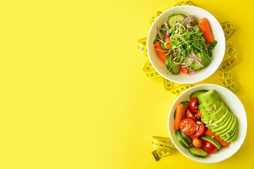 Bowls with fresh vegetable salad and measuring tape on color background