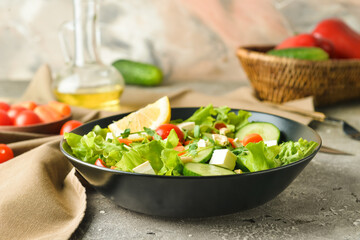 Plate of delicious fresh vegetable salad with feta cheese on grunge table
