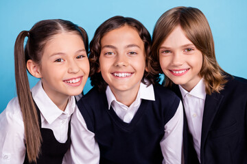 Photo portrait school mates smiling in uniform cheerful overjoyed isolated pastel blue color background