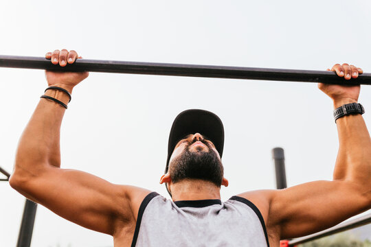 Guy doing pull-ups on pole