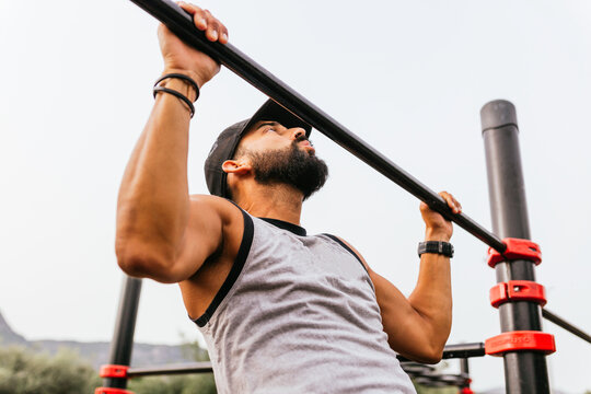 Guy doing pull-ups on pole