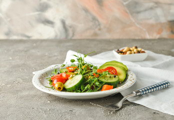 Plate of delicious fresh vegetable salad on grunge background