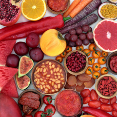 Healthy food high in lycopene to boost immune system with fruit and vegetables, high in antioxidants, anthocyanins, vitamins, beta carotene,  minerals, dietary fibre. Natural healthcare concept. 