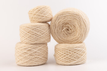 balls of light woolen thread on white background. natural wool. knitting. background