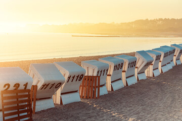 backs of Baltic Sea beach chairs with numbers in the morning sunlight 