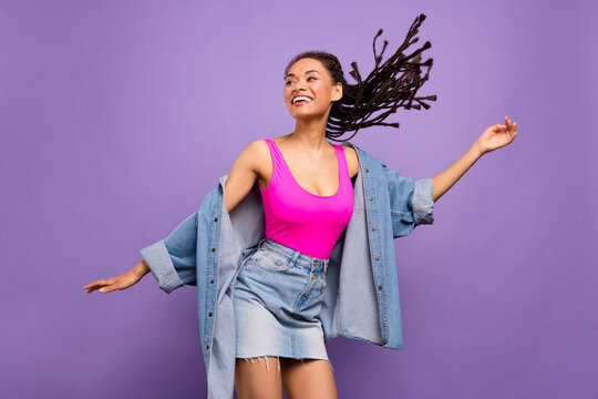 Portrait of attractive carefree slim trendy girl dancing having fun resting isolated over bright purple violet red color background