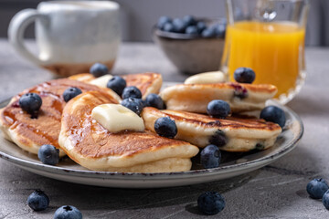 Buttermilk blueberry pancakes with maple syrup and fresh blueberries