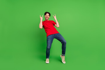 Fototapeta na wymiar Photo of rocker funny fan guy enjoy concert show two horns gesture wear red t-shirt isolated green color background