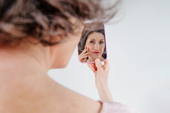 Portrait of mature woman looking at mirrow
