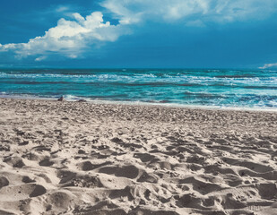 Fototapeta na wymiar Ocean coast. White sand and azure blue ocean with beautiful clouds.